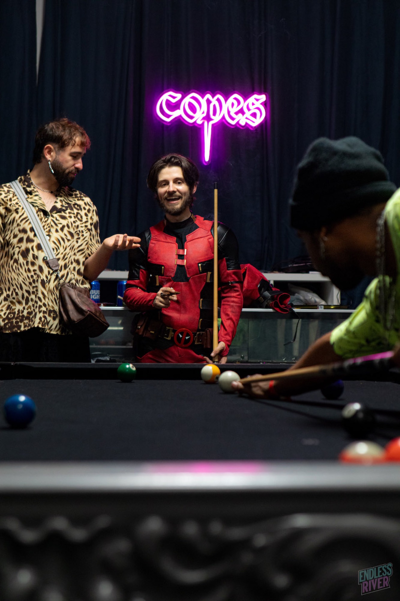 Guests playing pool under neon at an Omni House event